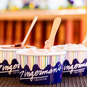 An arrangement of three 5 ounce cups of different flavors of Zingerman's gelato with small wooden spoons sticking out of each one.