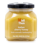 A jar of Mieli Thun Italian Cherry Honey. the jar is short and square with a black lid.
